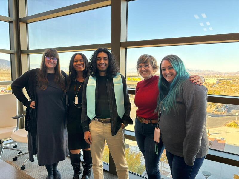 Photograph of Juan Diaz wearing his honors stole, standing with his thesis committee. From left to right: Heather Lang-Cassera, Shartriya Collier, Juan Diaz, Molly Appel (advisor), and Brianne Taormina.