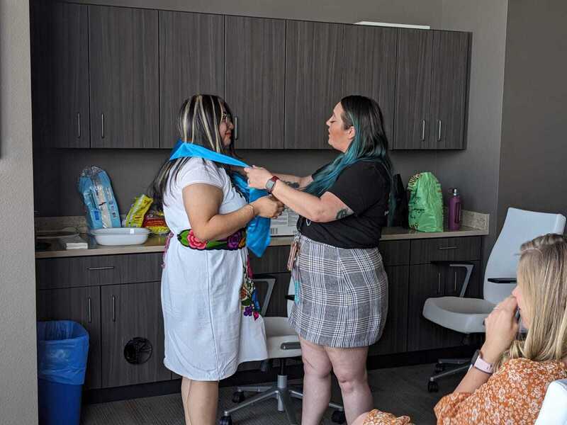 Photograph of Jalees Tamayo being granted her honors stole by her advisor, Brianne Taormina.